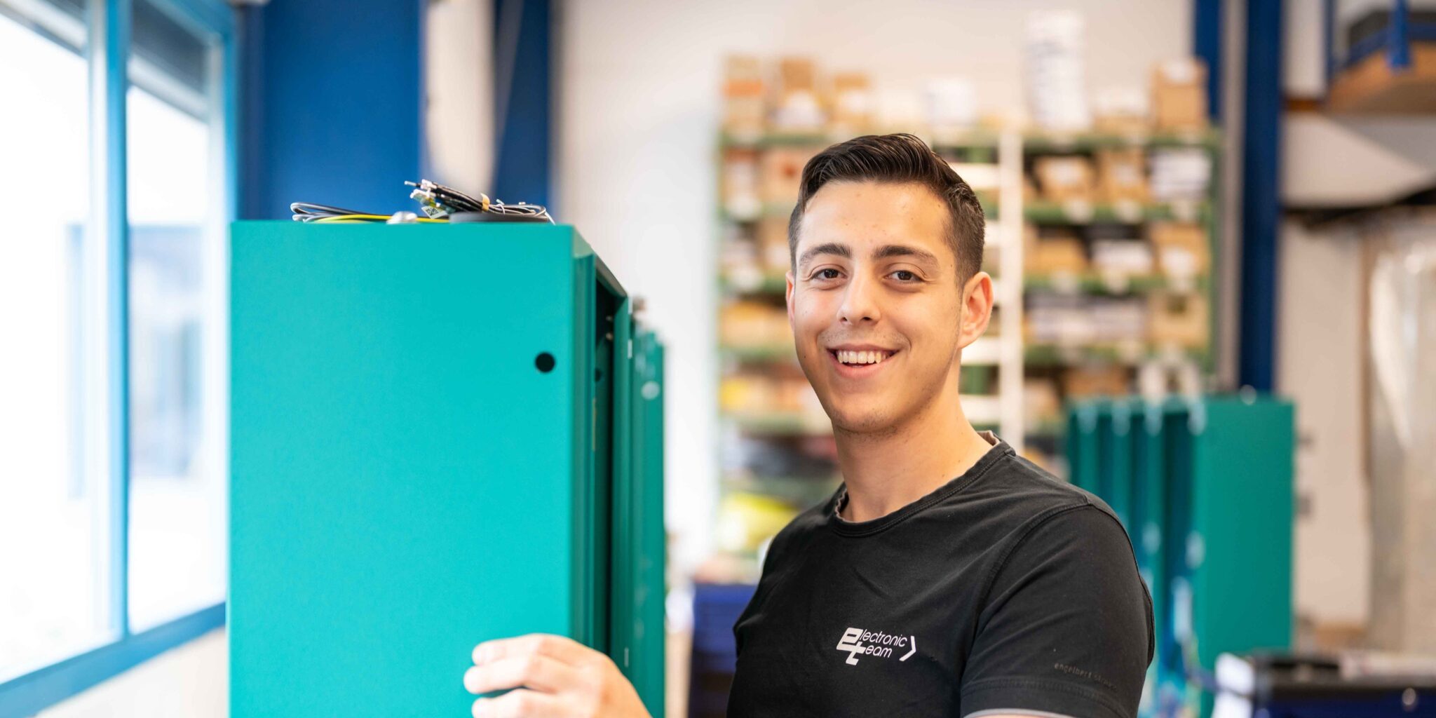 Foto eines Elektrikers der et electronic team GmbH bei der Arbeit an einem Schaltschrank.
